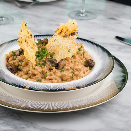 Wild Bolete Mushroom Risotto - Creamy Arborio rice infused with the rich, earthy flavors of wild bolete mushrooms. A comforting Italian main course, garnished with fresh parsley.