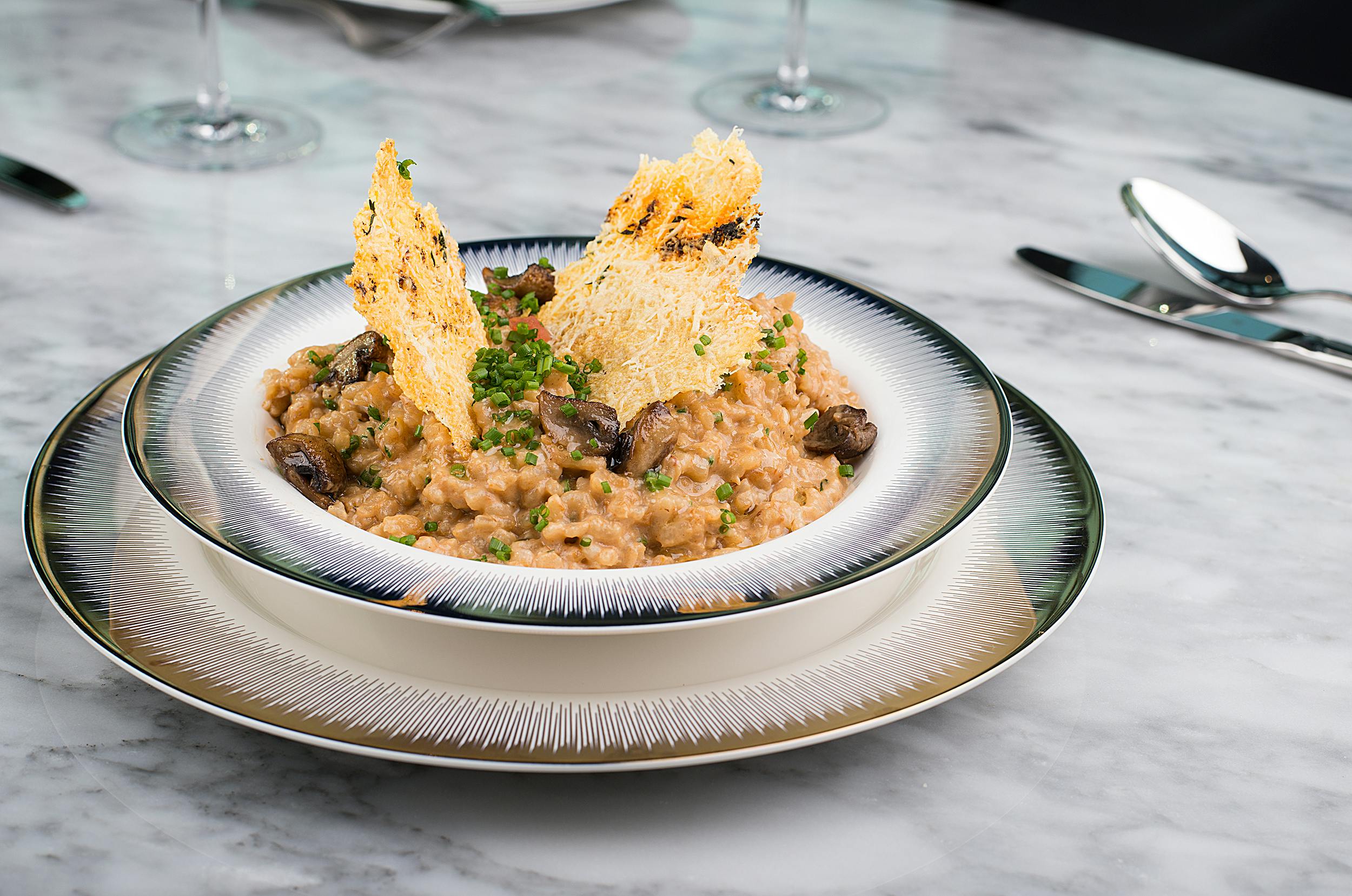 Wild Bolete Mushroom Risotto - Creamy Arborio rice infused with the rich, earthy flavors of wild bolete mushrooms. A comforting Italian main course, garnished with fresh parsley.