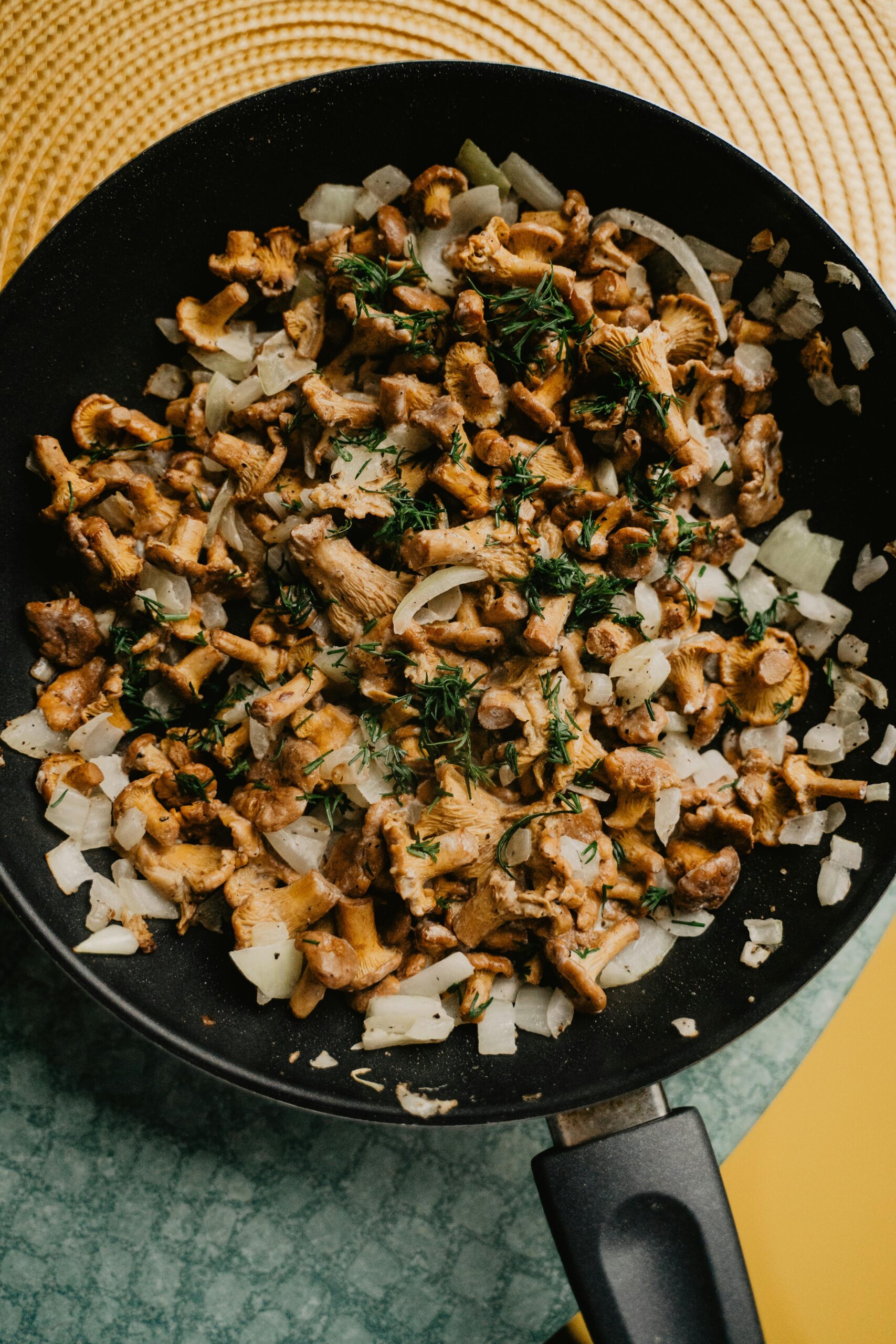 A skillet filled with sautéed wild mushroom medley with herbs and garlic.